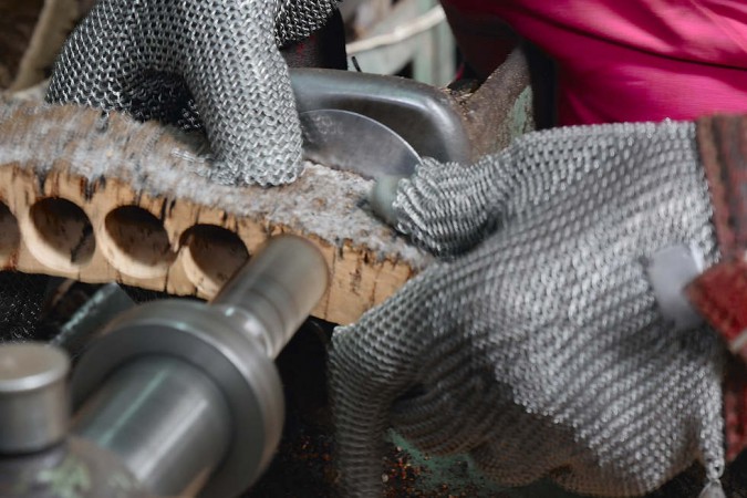 Es braucht geübte Fachleute, die das Maximum an intakten Korken aus der wertvollen Rinde stanzen. Die Metallhandschuhe schützen vor Verletzungen.